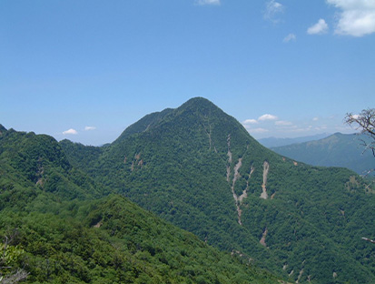 青空の下に広がる庚申山の稜線風景