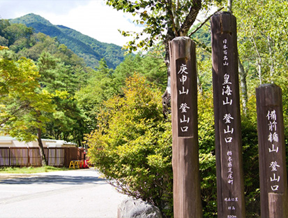 庚申山登山口と書かれた木製の案内標識が立つ登山口の風景