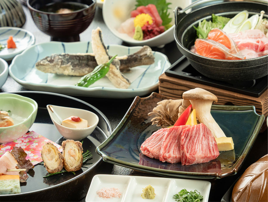 和食の会席料理が並ぶテーブル（焼き魚やお肉）