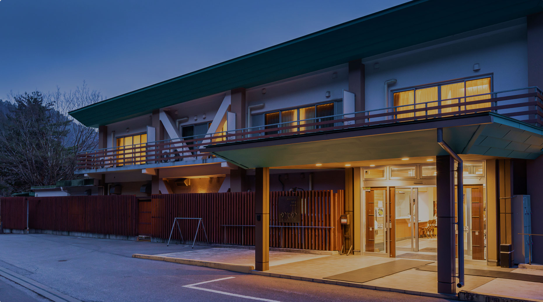 和風旅館の夜の外観と灯りがともるエントランス