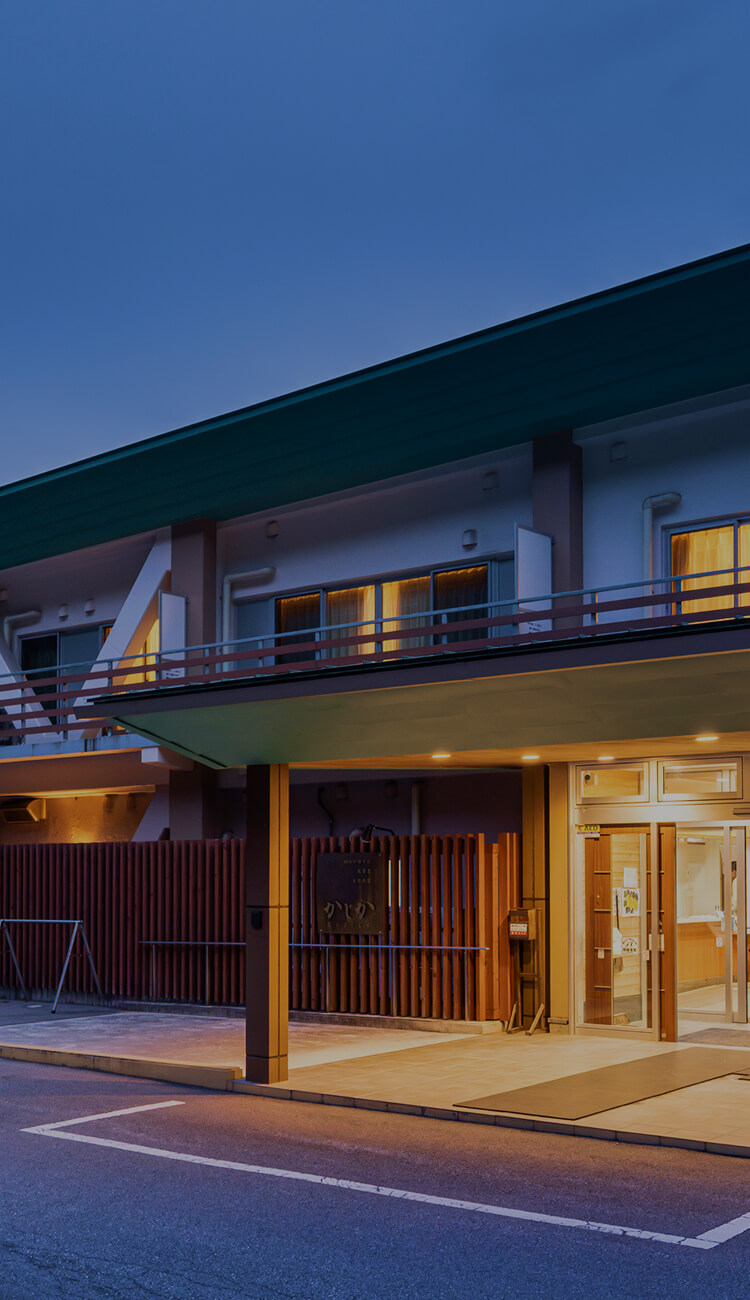 和風旅館の夜の外観と灯りがともるエントランス